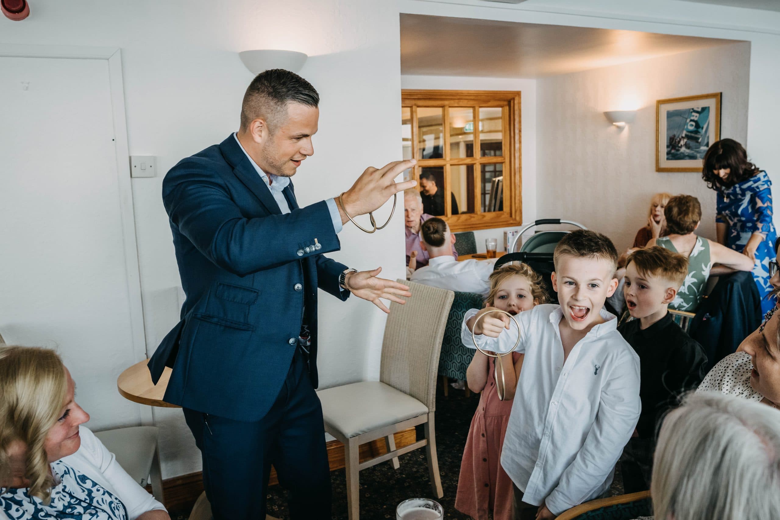 Guests of different ages reacting together during a lively wedding reception.