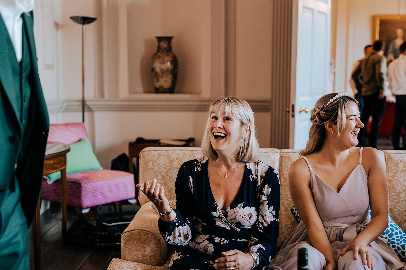 Wedding guests laughing together during close-up magic at Boconnoc Estate.