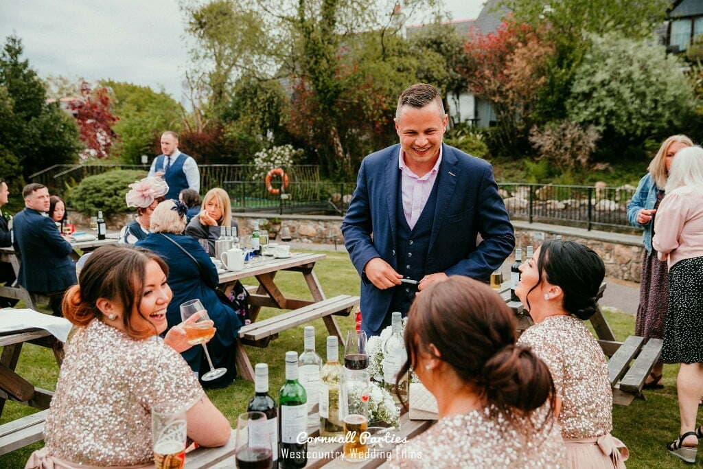 Lewis Belcher engaging guests at an outdoor drinks reception.